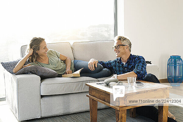 Couple smiling at each other on couch in modern home