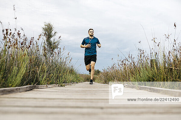 Jogger running on a wooden walkway