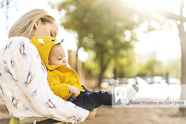 Mother carrying baby boy in a park