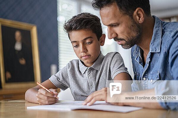 Father helping son doing homework