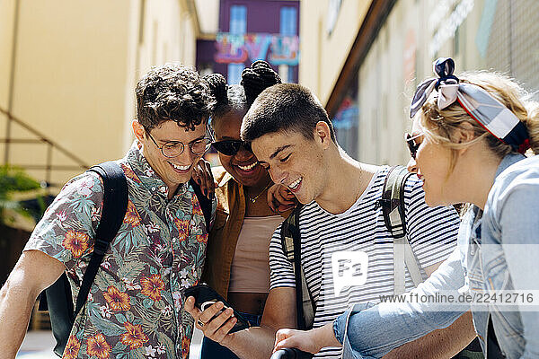 Students meeting in a backyard  talking  unsing smartphones