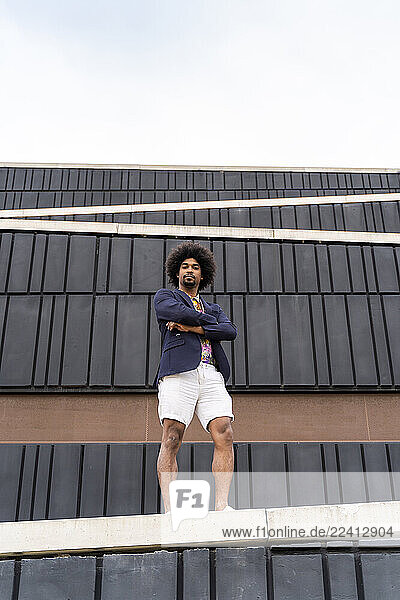 Portrait of stylish man standing on a wall