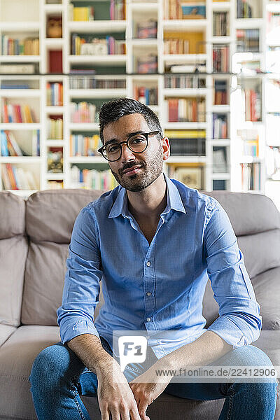 Portrait of young man sitting on the couch at home