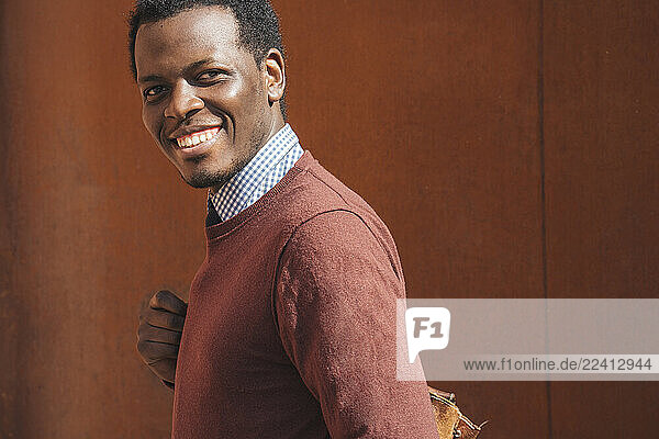 Portrait of a smiling young man  carrying bag