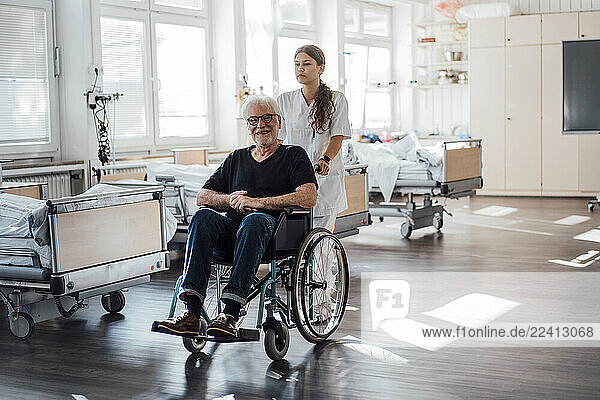 Nurse assisting patient in wheelchair at clinic