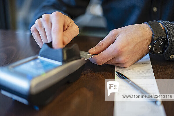 Young man making a payment with a credit card in a business setting