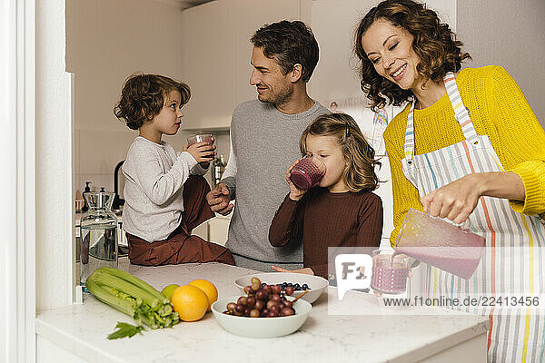 Mother preparing a smoothie for her family in kitchen