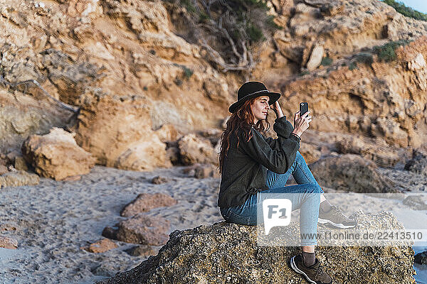 Young woman using smartphone on beach during sunset  Ibiza