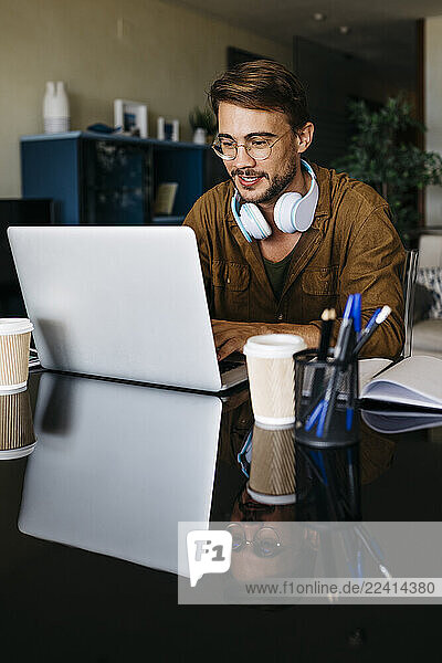 Man working on table at home using laptop
