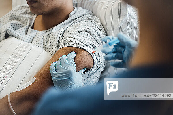 Doctor administering injection to patient in clinic