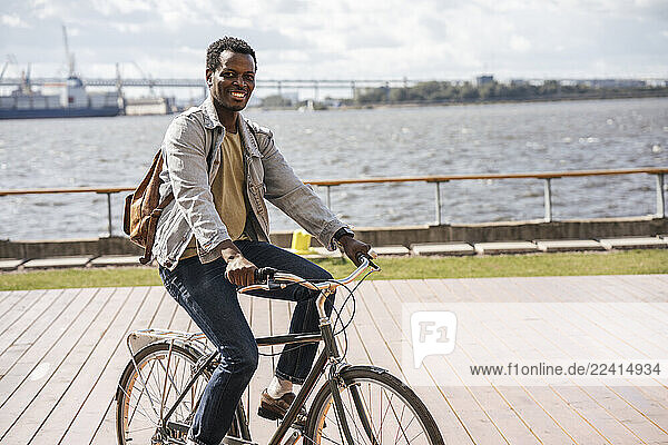 Young man riding bicycle at the sea