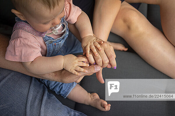 Hands of parents and baby girl