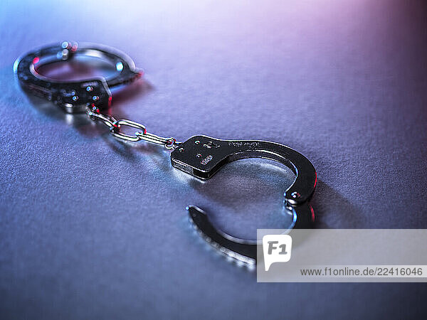 Open handcuffs on a surface symbolizing justice and crime