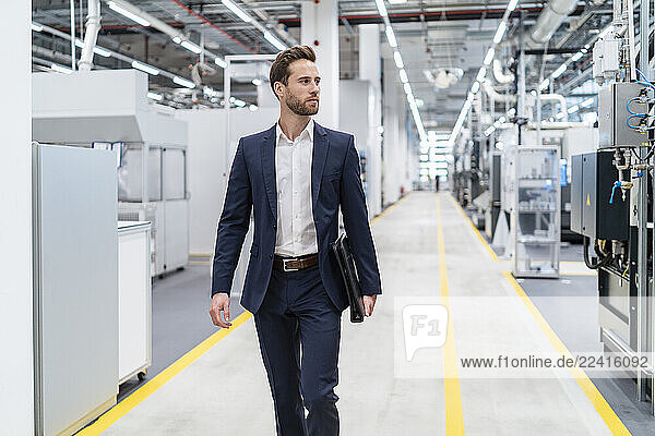 Businessman walking in a modern factory