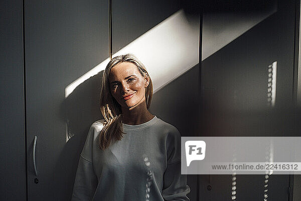 Doctor standing in a clinic with sunlight and shadows indoors