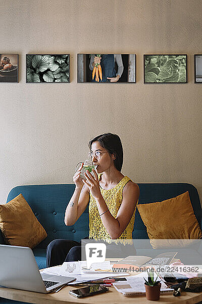 Fashion designer sitting on couch having a break and drinking tea