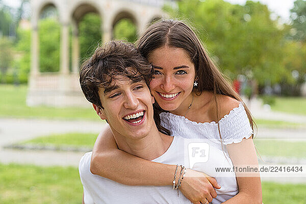 Young couple  man Carrying the woman on his back in a park