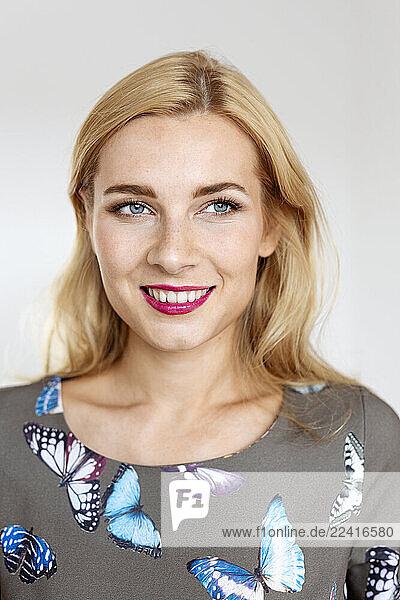 Portrait of a young woman wearing a dress with butterfly imprint