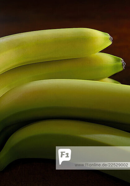Close-up of fresh green bananas against black background