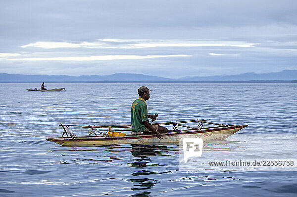 Early morning fishermen on outrigger canoe in the Alotau Bay. Alotau is the capital of Milne Bay Province  a province of Papua New Guinea. The town is located within the area in which the invading Japanese army suffered their first land defeat in the Pacific War in 1942  before the Kokoda Track battle. A memorial park at the old battle site commemorates the event. Alotau became the provincial capital in 1969 after it was shifted from Samarai. Alotau is the gateway to the Milne Bay Province which contains some of the most remote island communities in the world. Renowned for its friendly people and amazing tropical islands  it is a very well kept secret and sees very few tourists each year. The whole of Milne bay offers some of the worlds best scuba diving and coral reef experiences. Alotau itself is a busy regional Outpost -like town. Most facilities are available here although it can be sporadic at times.