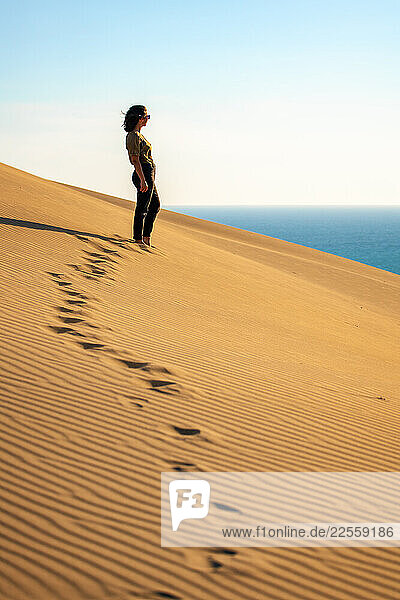 Woman observing the sea from Patara beach sand dunes in Turkey