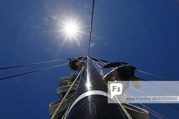 Two men climbing the rig on board Alfa Romeo during a test sail in Sydney Australia in preparation for the Rolex Sydney to Hobart 2009.