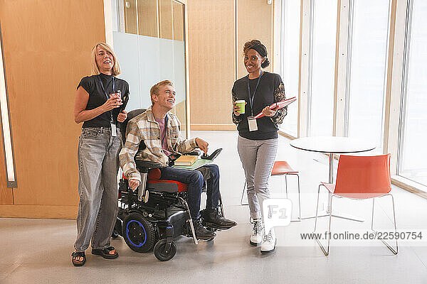 Man in wheelchair and coworkers in office