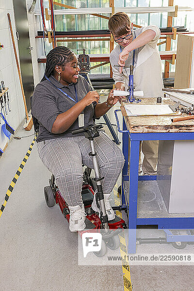 Disabled man and woman working in workshop