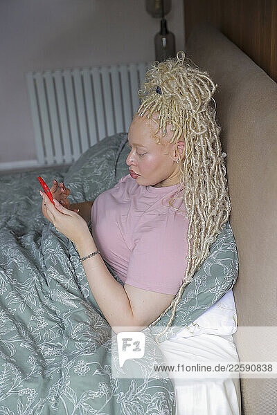 Woman with smart phone in bed