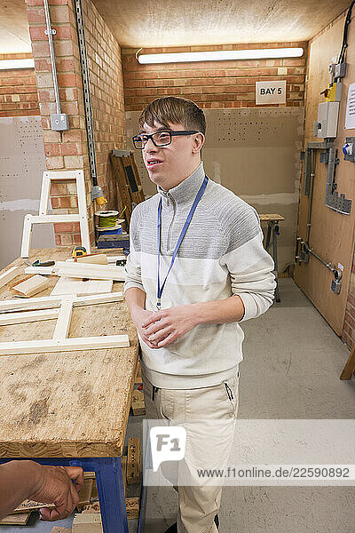 Man with Down Syndrome standing in workshop