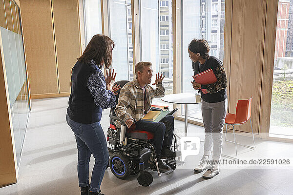 Man in wheelchair and coworkers in office
