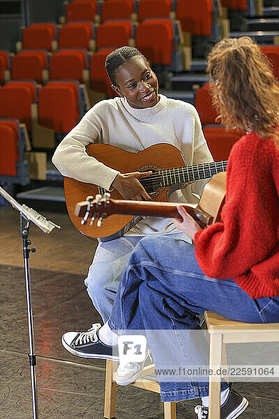 Women with disabilities playing guitars on stage