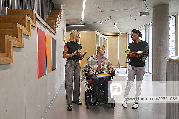 Man in wheelchair and coworkers in office
