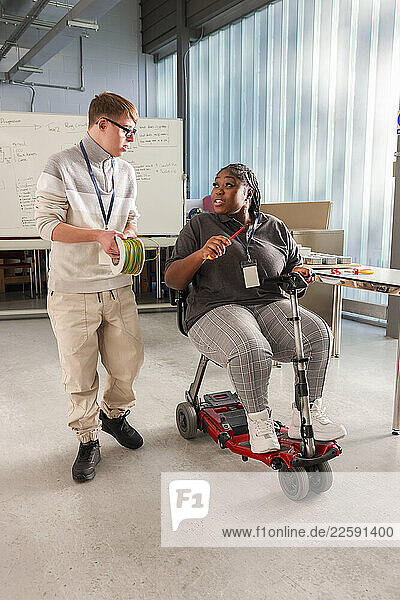 Disabled man and woman talking in workshop