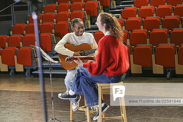 Women with disabilities playing guitars on stage