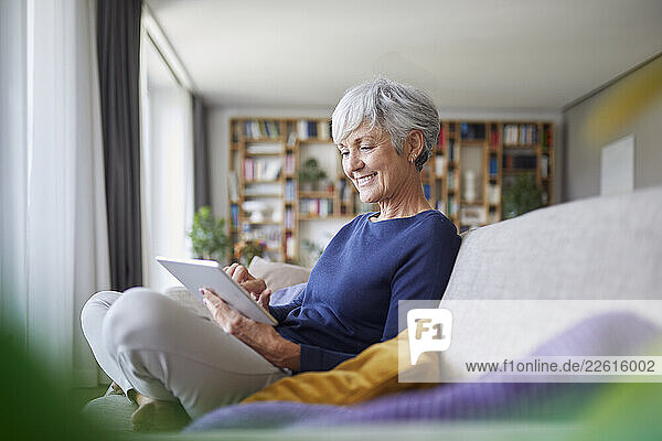Senior woman at home using a tablet and smiling