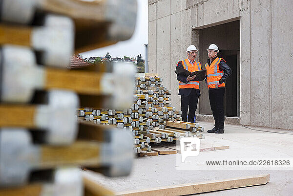 Engineers inspecting a construction site wearing safety vests and hard hats