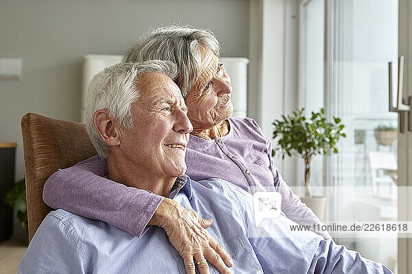 Senior couple enjoying a peaceful moment at home embracing each other
