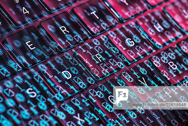 Close-up of a glowing keyboard with digital code representing cybersecurity and cyber crime concepts