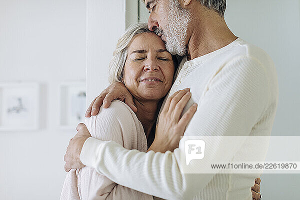 Affectionate mature couple hugging at home
