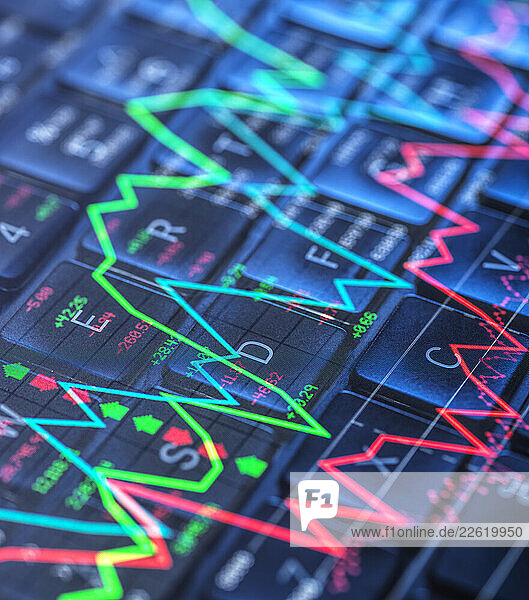Colorful stock market graphs overlaid on a computer keyboard representing financial data and analysis