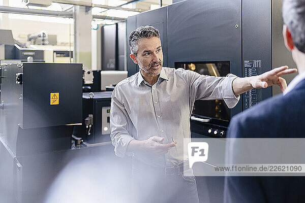 Businessmen in factory  having a meeting  discussing solutions