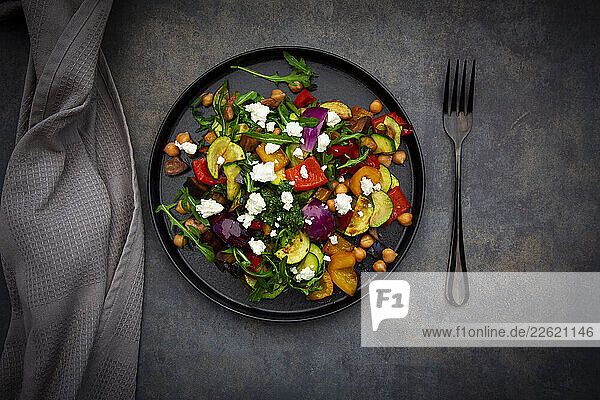 Mediterranean salad with roasted vegetables  pesto  and sheep cheese on a dark background