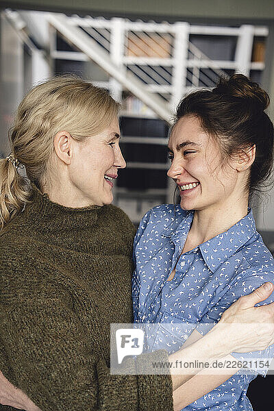 Mother and daughter embracing at home  smiling and showing affection