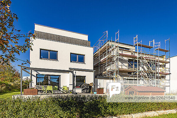 Modern single-family homes under construction with scaffolding in Weinstadt  Germany