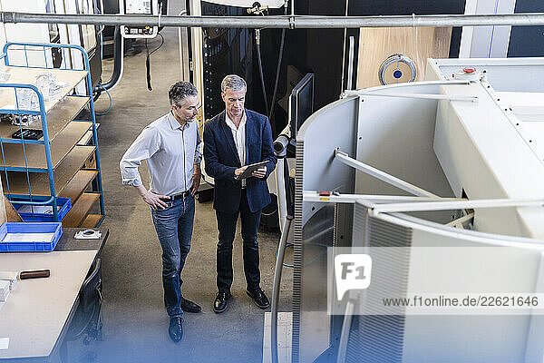 Businessmen in factory having a meeting in production hall