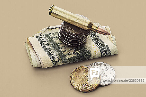 US Defense Spending - bullet cartridge and coins on US money bills