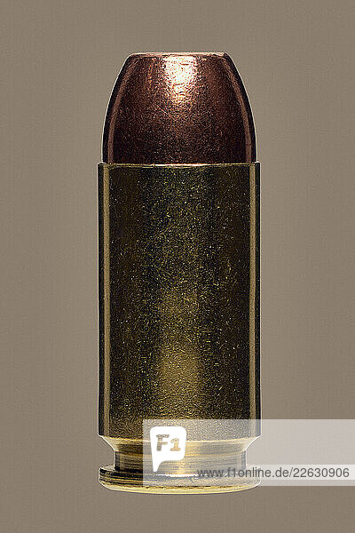 Close up .40 bullet on brown background