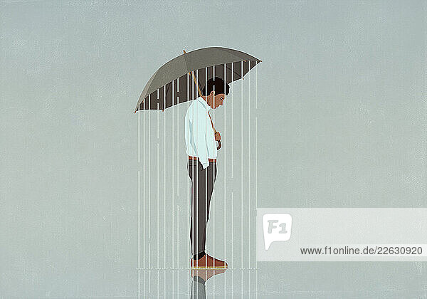 Rain falling from umbrella over depressed man