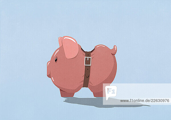 Belt tightening belly of piggy bank on blue background